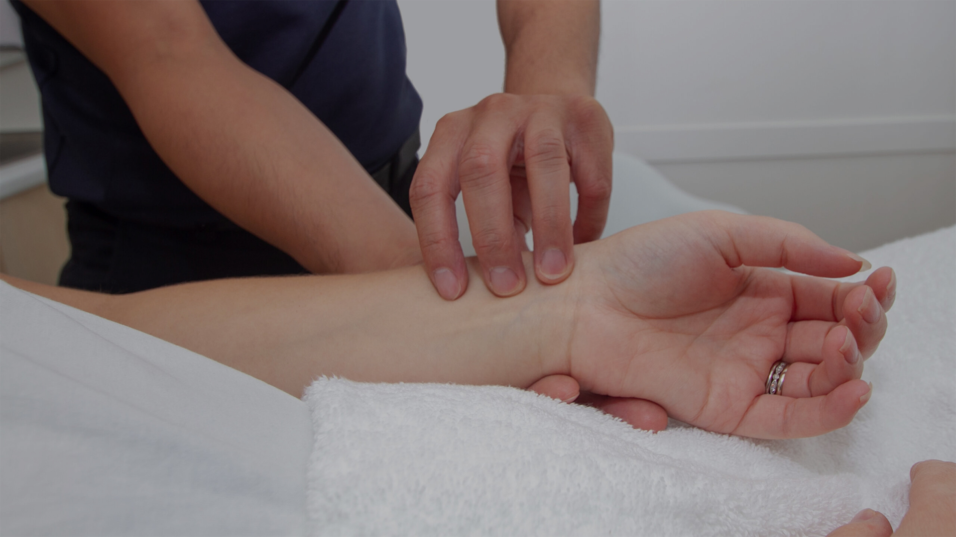 Acupuncturist checking the pulse of a woman's arm