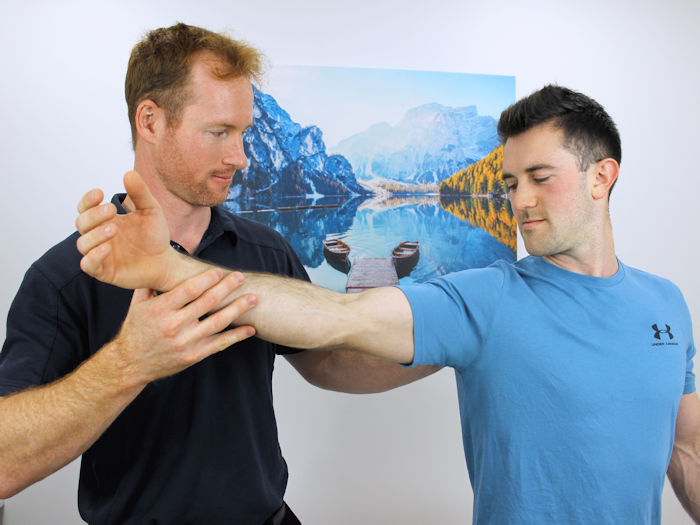 Practitioner assessing shoulder pain for treatment