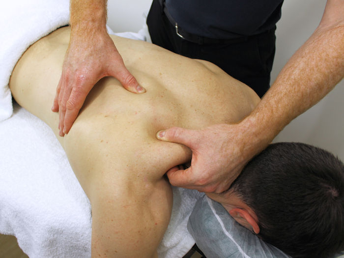 Patient receiving remedial massage for back and shoulder pain