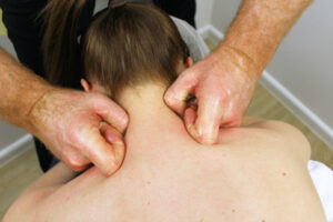 practitioner applying trigger point therapy for shoulder pain