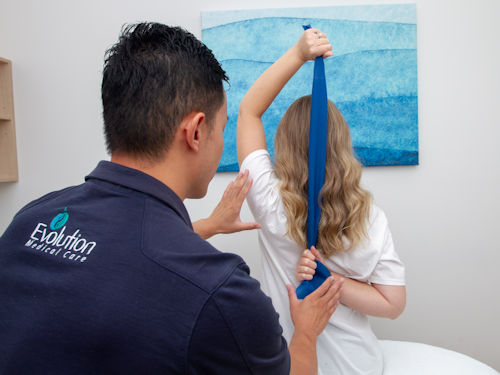 practitioner teaching patient stretches to help with shoulder bursitis