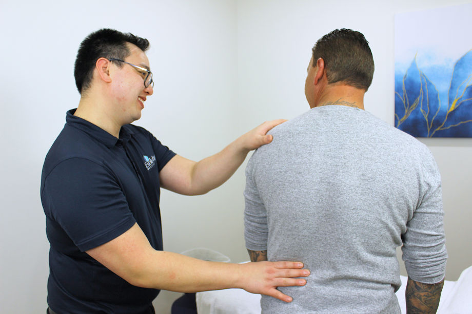 Acupuncturist consulting patient to help with bulging disc back pain