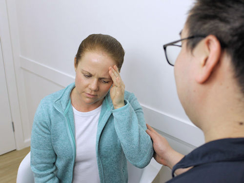 practitioner consulting with patienet experiencing headache pain