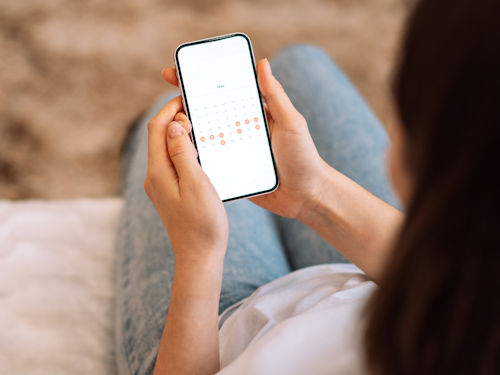woman using app to help track the phases of her menstrual cycle
