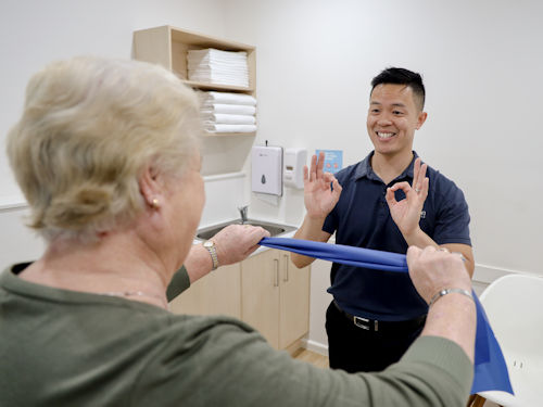Practitioner providing patient with strength training to help manage arthritis symptoms