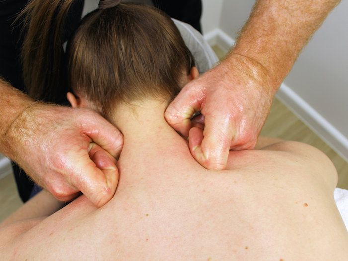 practitioner relieving patients neck pain through remedial massage and trigger point therapy