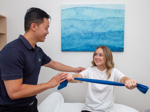 practitioner showing patient how to strengthen muscles to reduce bursitis pain