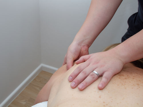 practitioner providing trigger point therapy to relive muscle tension to help with bursitis