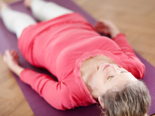 woman practicing progressive muscle relaxation to assist with stress related issues and TMJ pain