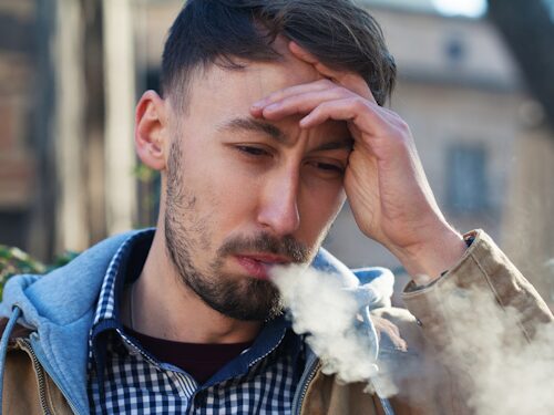 man smoking and experiencing chronic pain