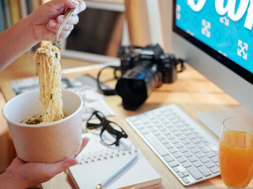 person eating in front of computer doing mindless eating effecting digestion