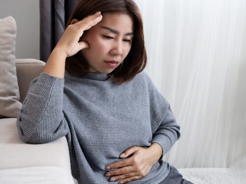 woman with upset stomach and sore head showing the relationship of the gut-brain axis