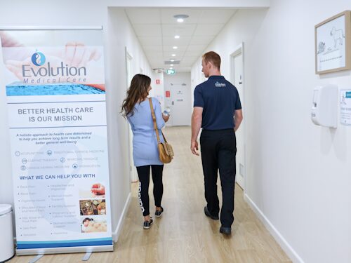 person being led into consultation by practitioner to dicuss and treat worsening pain in cold winter months