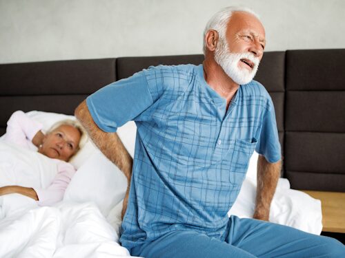 man waking up in pain with rheumatoid arthritis