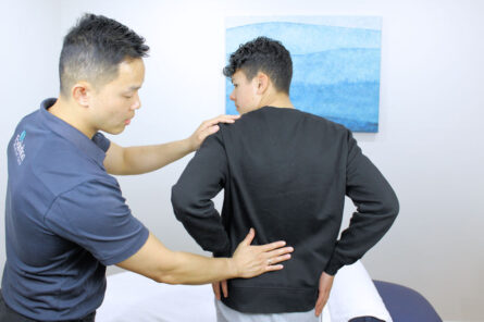 Practitioner providing assesment for lower back pain