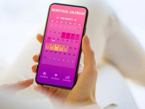 woman using smart phone app to help track her period for her fertility window